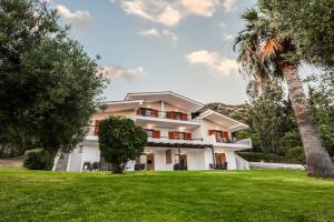 a large white house with a palm tree at Katerina's Garden Mola Kaliva in Mola Kalyva