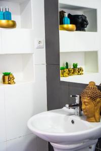 La salle de bains est pourvue d'un lavabo et d'une statue. dans l'établissement Morabezahome - Zaza, à Mindelo