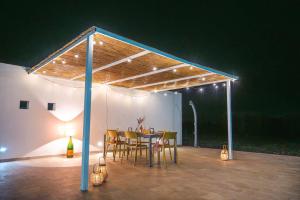 a patio with a table and chairs under a roof at Villa Donnosanto a 5 minuti dalla spiaggia, Ostuni 10 minuti in Torre Santa Sabina