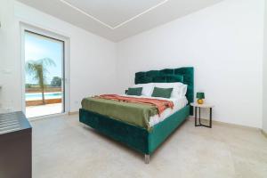 a bedroom with a large bed and a large window at Villa Donnosanto a 5 minuti dalla spiaggia, Ostuni 10 minuti in Torre Santa Sabina