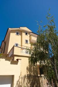 a building with a fence in front of a tree at Zlatna Ribka in Chernomorets