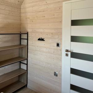 a room with wooden walls and a closet with wooden shelves at Stumilowy Las - Białe Domki in Mielenko