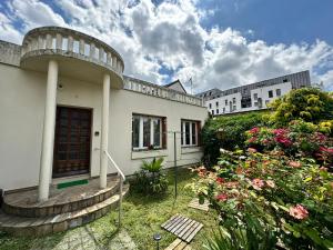 a building with a bunch of flowers in the yard at Appt Cosy - Proche Paris - Ideal Couple in Fresnes