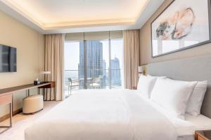 een slaapkamer met een groot wit bed en een groot raam bij Luxe 3-BR in Address Dubai Opera with Full Burj View in Dubai +42 foto's