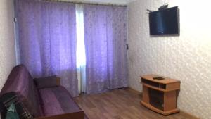 ein Wohnzimmer mit einem lila Sofa und einem Tisch in der Unterkunft 2к Апартаменты возле ЖД вокзала и Академии 096-55-48-111 in Chmelnyzkyj