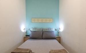 a bedroom with a bed with a blue wall at Casa Vacanze L'Aquilone - casa sulla spiaggia - baia di Porto Rafael in Palau