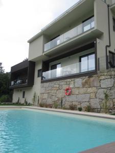 a house with a swimming pool in front of a building at Gerês Valley in Geres