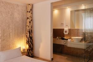 ein Badezimmer mit einem Bett, einem Waschbecken und einer Dusche in der Unterkunft 18Arts Hotel - Living in a Gallery! in Köln