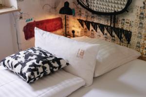 ein Bett mit zwei Kissen darüber in der Unterkunft 18Arts Hotel - Living in a Gallery! in Köln