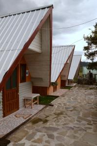 a row of wooden buildings with white roofs at Casa Florea in Poiana Stampei