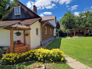 a house with a garden and flowers in the yard at У ДЯДЬКА in Pilipets