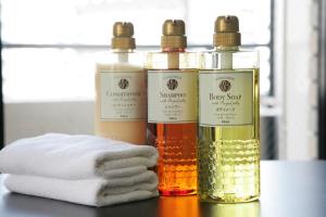 three bottles of essential oils on a table with towels at The HARBOR 天神東 in Fukuoka +41 photos