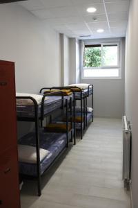 a row of bunk beds in a room with a window at Albergue Bide-Ona in Portugalete