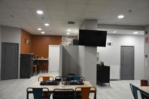 a room with a table and chairs and a tv at Albergue Bide-Ona in Portugalete