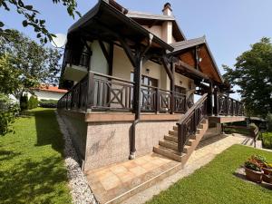 a house with a balcony and a staircase on it at Sarajevo Villa Ruza Vjetrova in Vinogradi