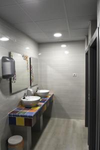 a bathroom with two sinks and a mirror at Albergue Bide-Ona in Portugalete