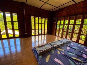 a room with a large bed in a room with windows at MAE-TON LUANG Camping in Ban Pang Haen