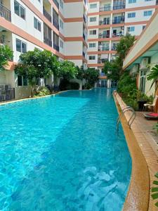 a swimming pool in front of a building at Fully Furnished Condo Park Lane Resorts 2314 in Jomtien Beach
