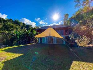 a large yellow tent in front of a house at MAE-TON LUANG Camping in Ban Pang Haen