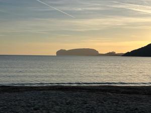 a beach with two large rocks in the water at The Arches House Bed and Breakfast IUN F1092 in Alghero
