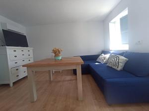 a living room with a blue couch and a table at Casi Las Doce in Cazorla