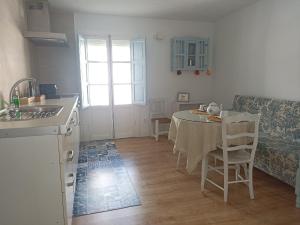 a kitchen and dining room with a table and a couch at Casi Las Doce in Cazorla