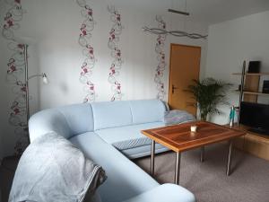 a living room with a blue couch and a table at Ferienwohnung Schruttke in Bad Frankenhausen