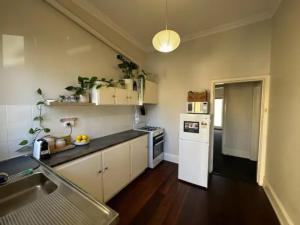 une cuisine avec un évier et un réfrigérateur blanc dans l'établissement 1BR Apt 2 min away from Fremantle Hospital - Hosted by Canstay, à Fremantle