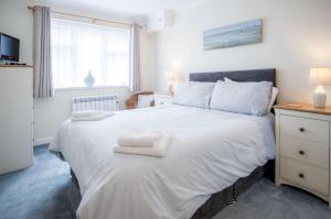 une chambre avec un grand lit blanc avec des serviettes dessus dans l'établissement Clover Cottage - 2 Bedroom Cottage - Begelly, à Saundersfoot