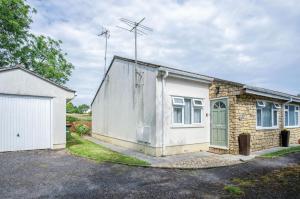 une petite maison blanche avec un garage dans l'établissement Clover Cottage - 2 Bedroom Cottage - Begelly, à Saundersfoot