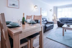 un salon avec une table de salle à manger avec des verres à vin dans l'établissement Clover Cottage - 2 Bedroom Cottage - Begelly, à Saundersfoot