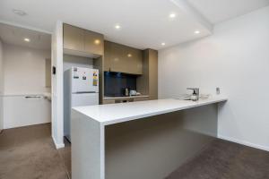 een keuken met een witte bar en een koelkast bij Kingston Foreshore with Garden View - Hosted by Canstay in Kingston 