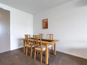 een eetkamer met een houten tafel en stoelen bij Kingston Foreshore with Garden View - Hosted by Canstay in Kingston 