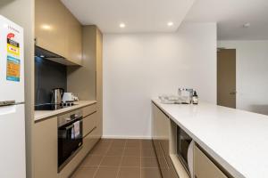 een keuken met witte werkbladen en een aanrecht bij Kingston Foreshore with Garden View - Hosted by Canstay in Kingston  +15 foto's