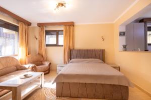 a bedroom with a bed and a couch and a table at Walter Home Bușteni with Private Terrace in Buşteni