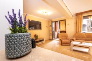 a living room with a vase with purple flowers in it at Walter Home Bușteni with Private Terrace in Buşteni