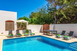 a pool with chairs and a ping pong table at Villa Las Mariposas by Villa Plus in Es Mercadal