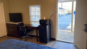 a bedroom with a desk with a computer and a television at Scottish Inns - Middletown in Middletown