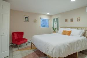 a bedroom with a large bed and a red chair at 2-BR City Retreat Peace Privacy & Parking in Washington, D.C.