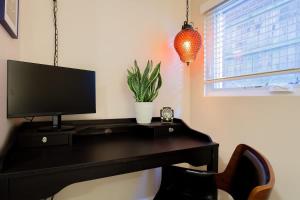 a black desk with a television on top of it at 2-BR City Retreat Peace Privacy & Parking in Washington, D.C.