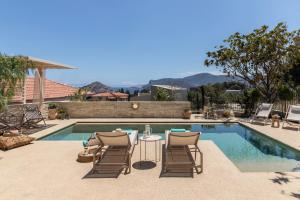 a swimming pool with chairs and a table next to a pool at Casa Meraki by A&D Properties in Porto Rafti