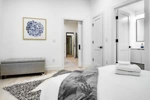 a white bedroom with a bed and a couch at Eastern Market & METRO Accessible Modern Charm Walk Everywhere in Washington, D.C.