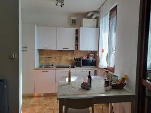 a small kitchen with white cabinets and a table at Blu Armony in Sirmione