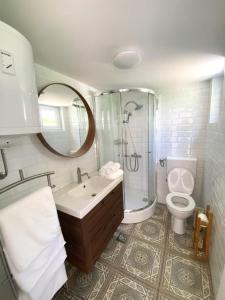 a bathroom with a sink toilet and a mirror at Calma bungalows in Portorož