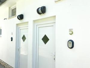 a white building with a door and a security camera at Calma bungalows in Portorož