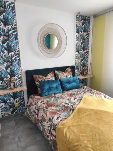 Mours-Saint-EusÃ¨beLa Villa d'A-Mours的卧室里有一张床，墙上有一面镜子 更多15张照片