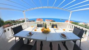 a table with a bowl of fruit on a balcony at Villa Apartments Mecajac in Cavtat