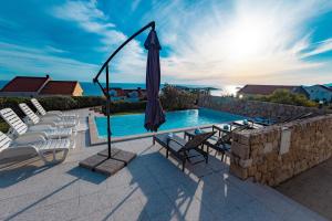 a swimming pool with chairs and an umbrella at Villa Apartments Mecajac in Cavtat