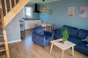 a living room with a blue couch and a table at Domki Luan Village in Władysławowo
