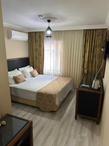 a bedroom with a bed and a television in it at Loost Town Inn Hotel in Antalya +42 photos